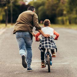 Father teaching his son how to ride a bike