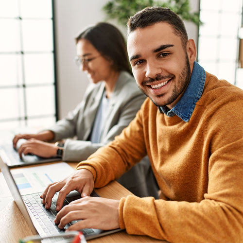 smiling young man working on his laptop