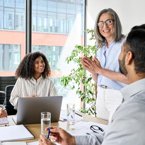 Smiling diverse corporate team working together in modern meeting room office.