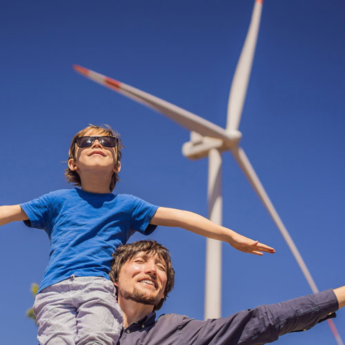 father and son outdoors near wind turbine
