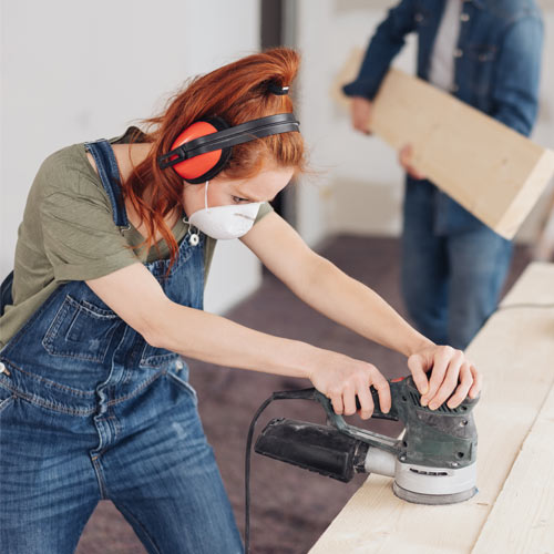 female sanding wood