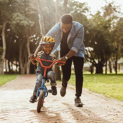 Father teaching his son how to ride a bike