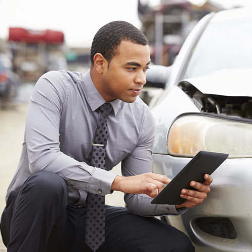 insurance agent inspecting car