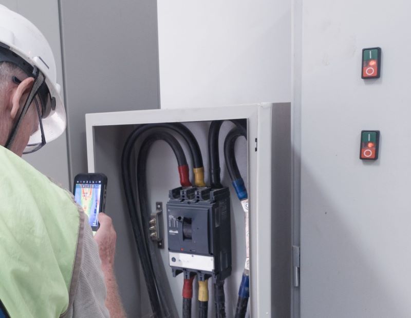Inspector using a thermographic image device to check electricals