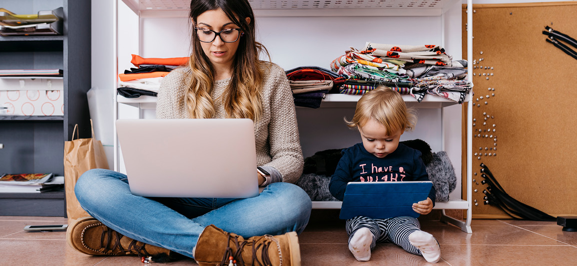 Mum and child sitting on floor on laptops