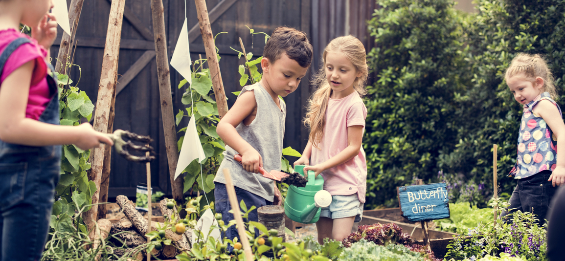 Two young children watering plants