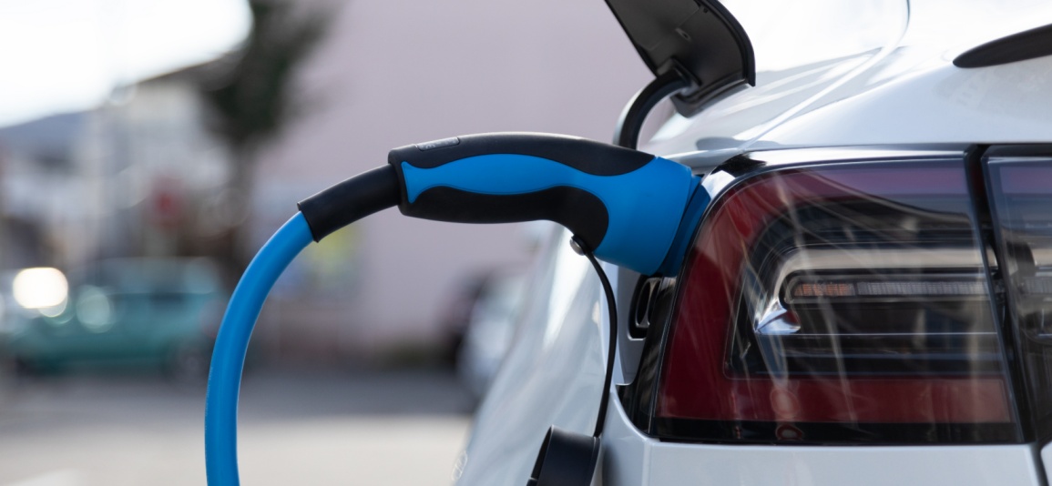 EV electric car plugged charging at a recharge station