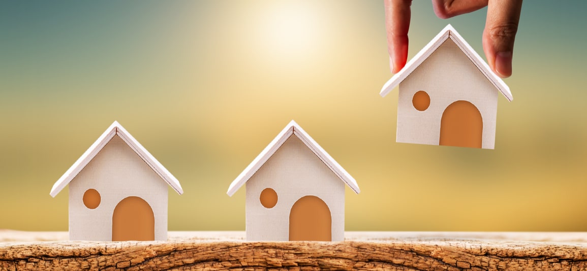 Woman hand holding a home model on the wood on sunlight