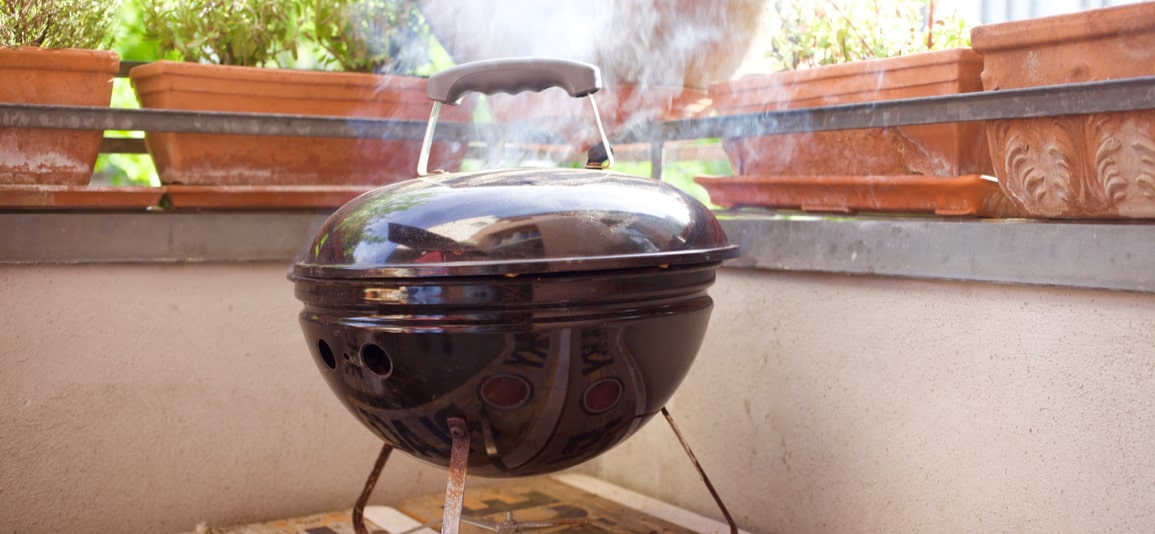 Smokey small bbq grill outside on balcony in spring