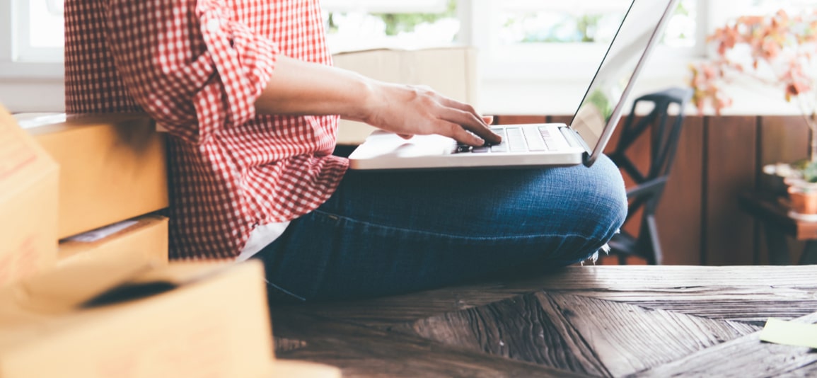 business owner checking laptop before shipping product
