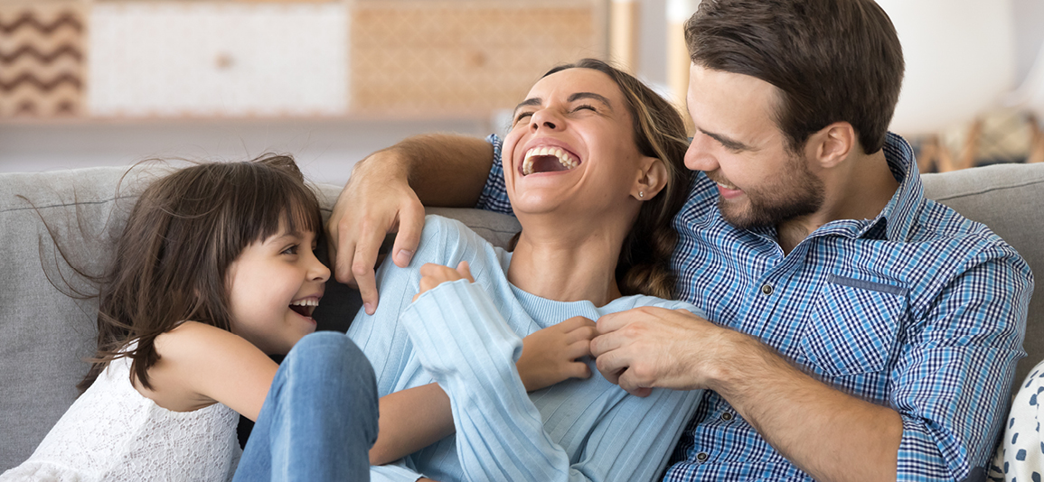 Cheerful people sitting on couch in living room have fun