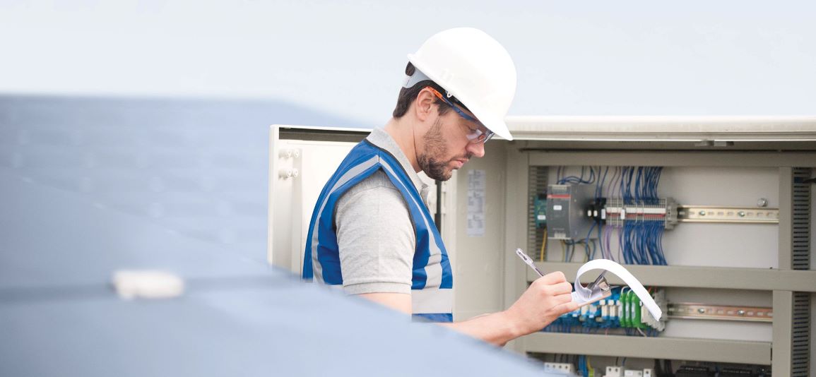  Man writing on clipboard in solar farm - close up