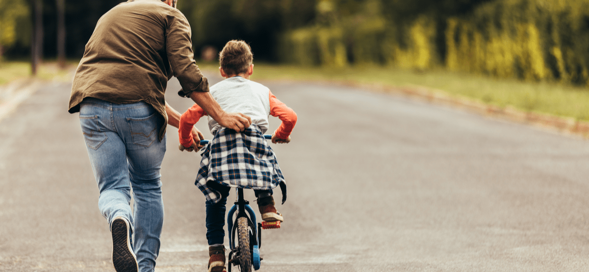Rear view boy riding bicycle while