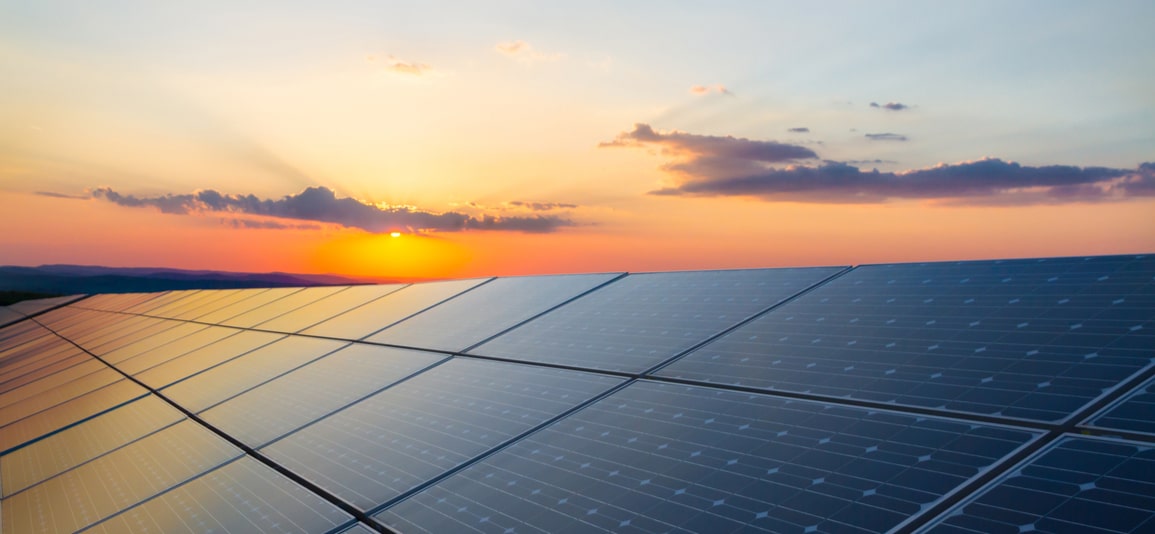 solar panels on roof with sunset