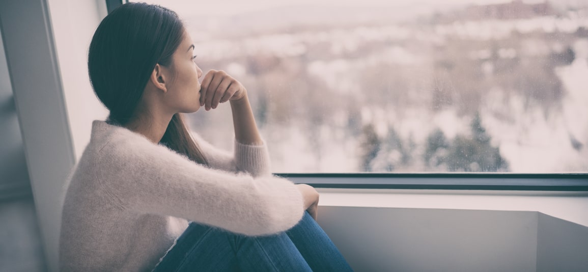 asian woman looking out the window