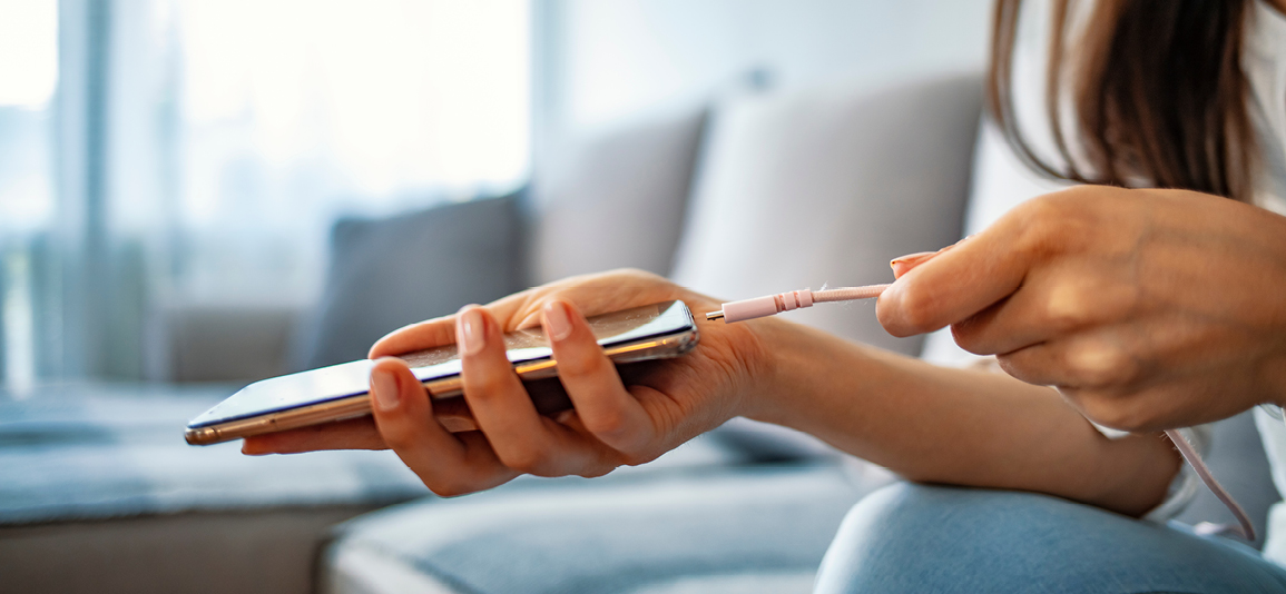 Woman hands plugging a charger in a smart phone.
