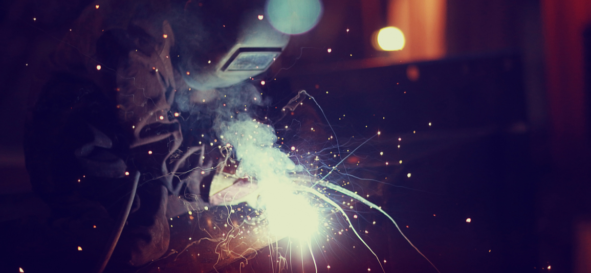 masked worker producing sparks