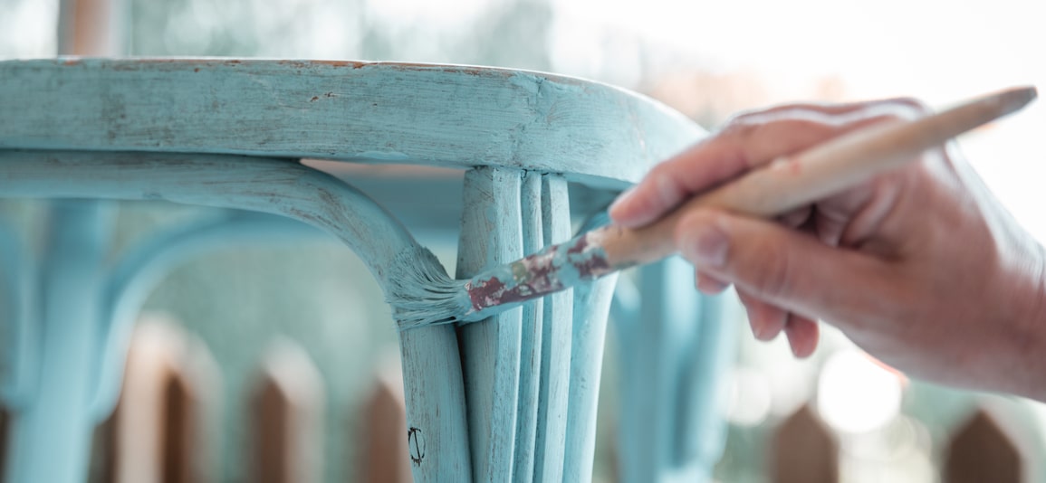 brush restores a wooden chair with turquoise paint