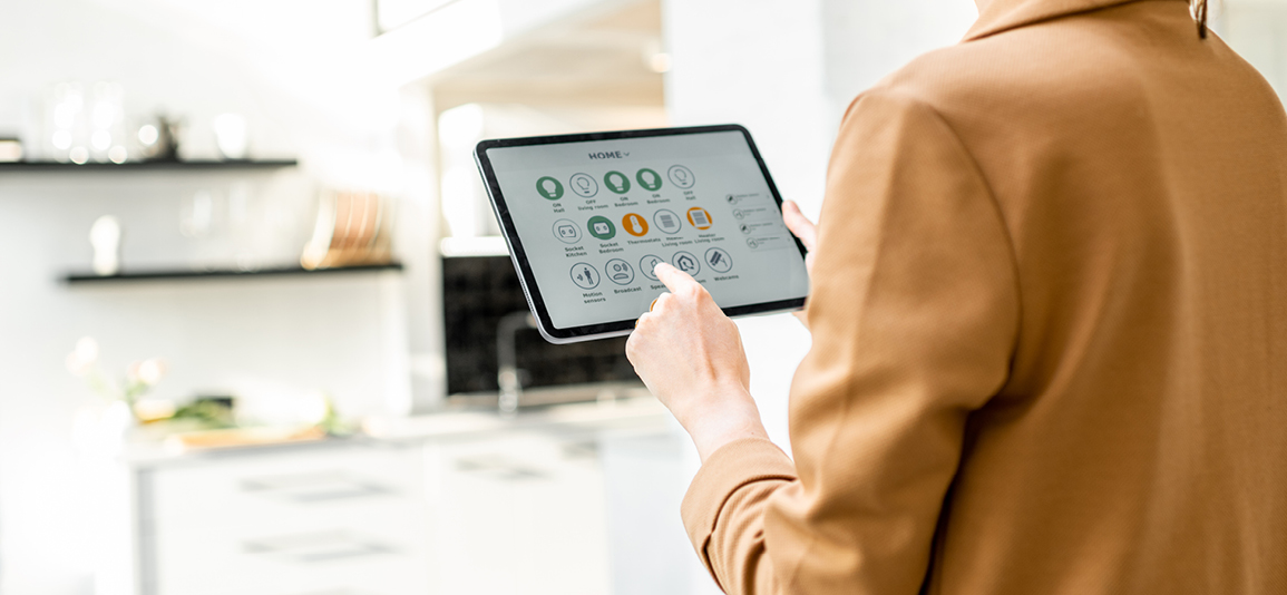 Woman controlling smart home devices using a digital tablet