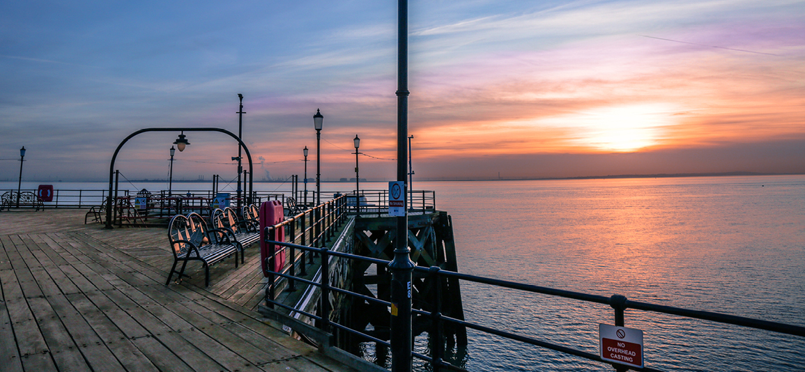 The pier from Southend on Sea with one of the lanterns in the middle, captured at sunset.