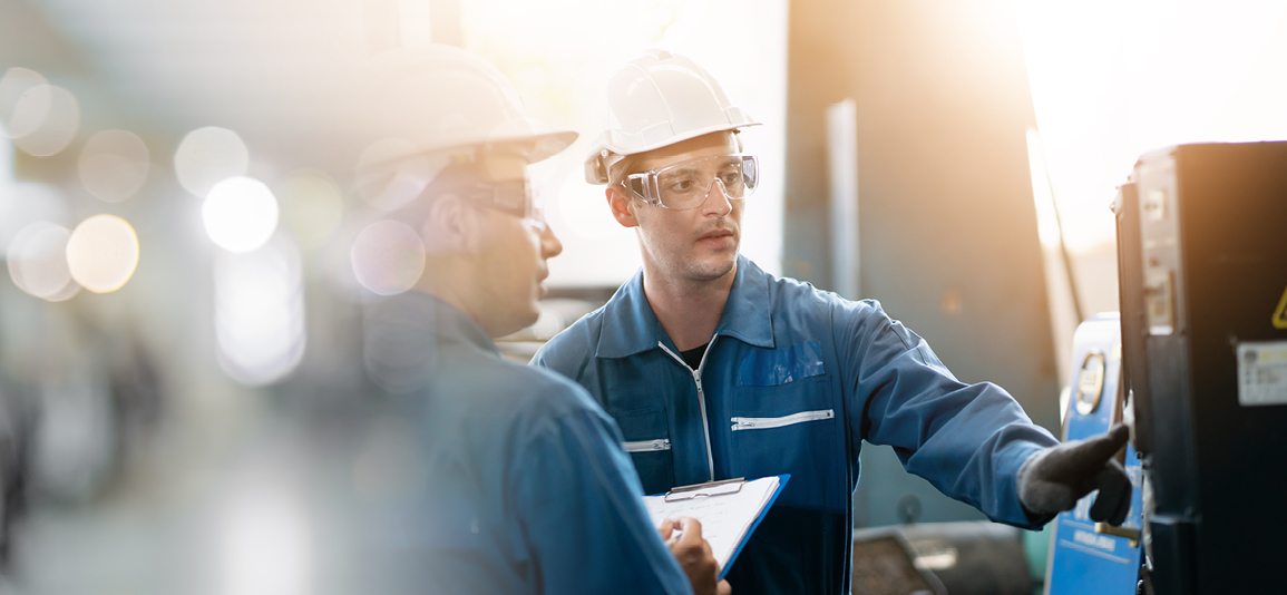 two male engineers inspecting machinery