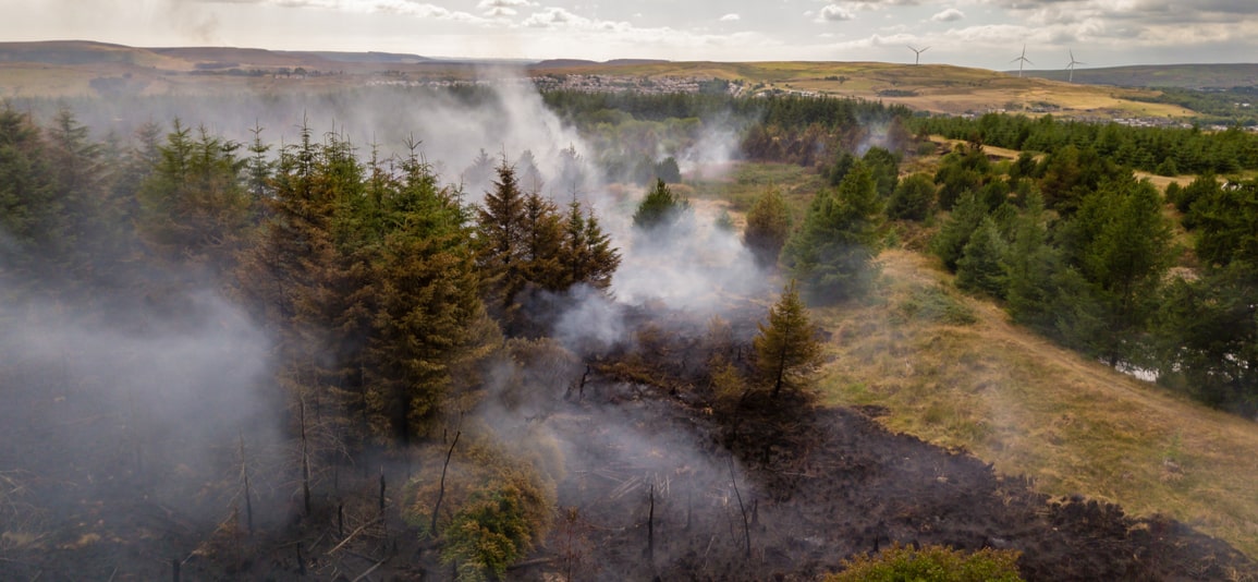 Aerial drone view of a smouldering wildfire in Wales, UK