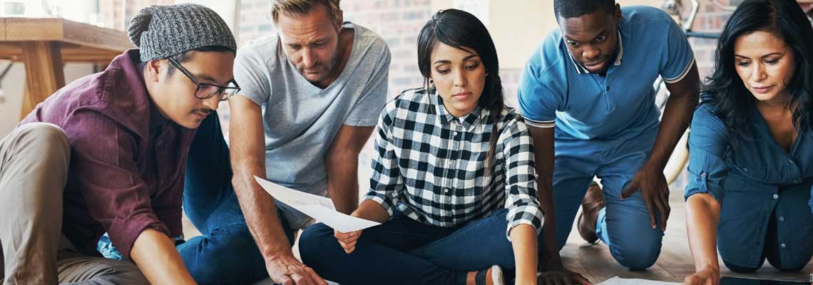 People working in office with paperwork on the floor