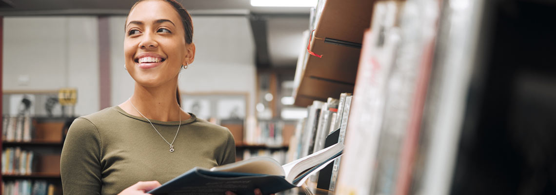 Student, happy and reading books in library