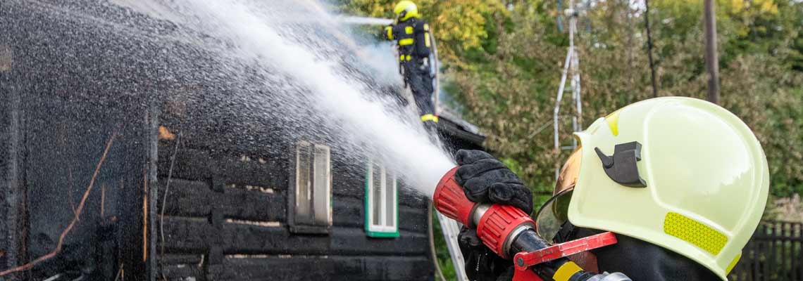 Fireman puts out the fire of an old wooden house