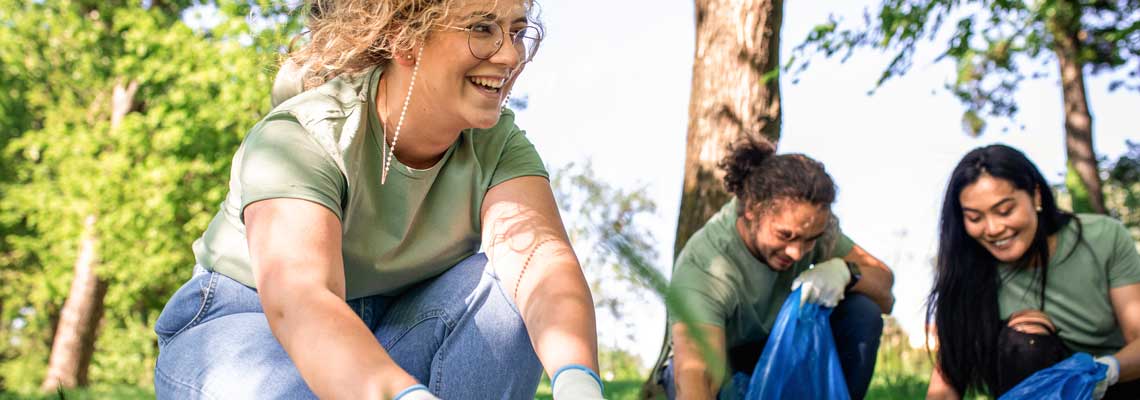 group of volunteers with garbage bags cleaning city park