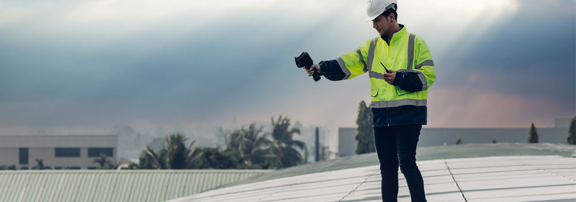 Engineer checking temperature of solar panels using thermos infrared