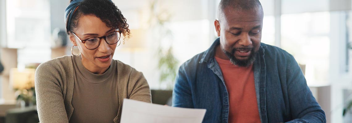 couple with bills reading documents