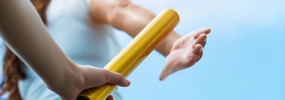 Two hands passing the baton for a relay race.