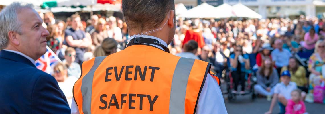 focus of an Event Safety officer seen facing members of the public in a town square