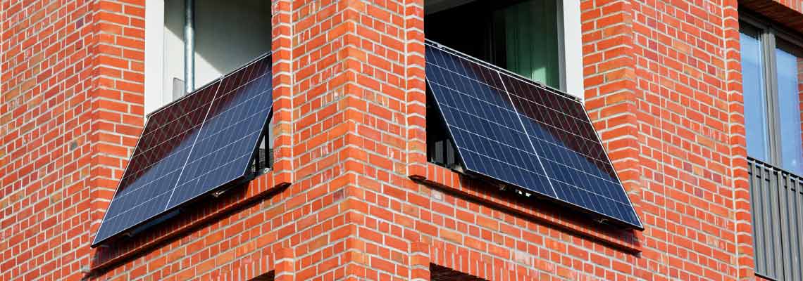 Brick building with balcony-mounted solar panels