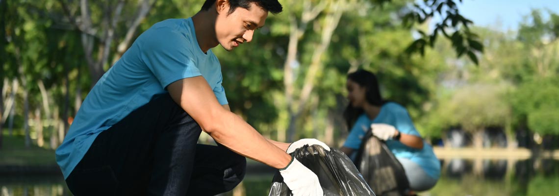 Male volunteer collecting rubbish at the park