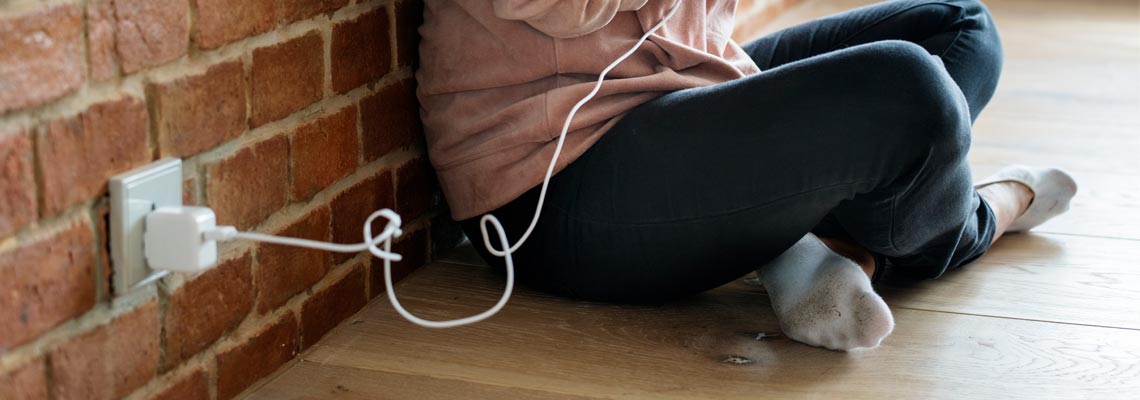 Young woman using a smartphone as it is being charged