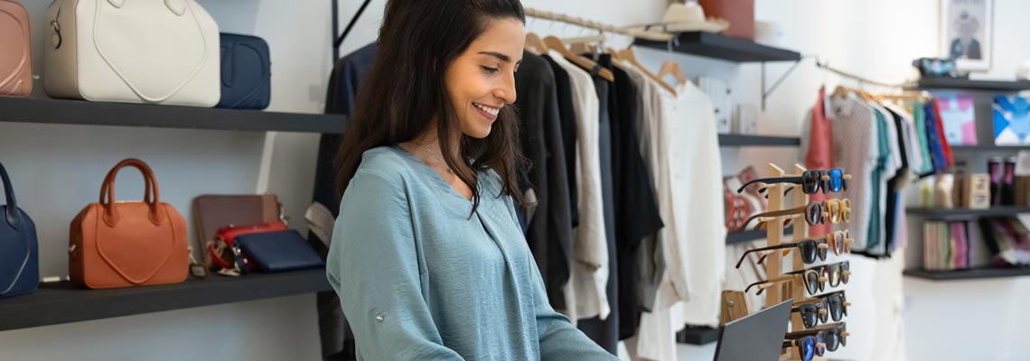 Young retail fashion store manager working at cash register counter