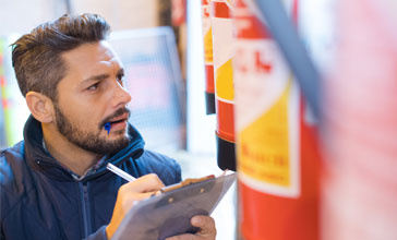 man inspecting fire extinguishers