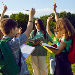 Group of school children learning about nature during outdoor lesson