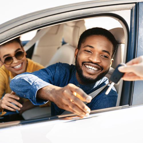 happy couple receiving the keys to their new car